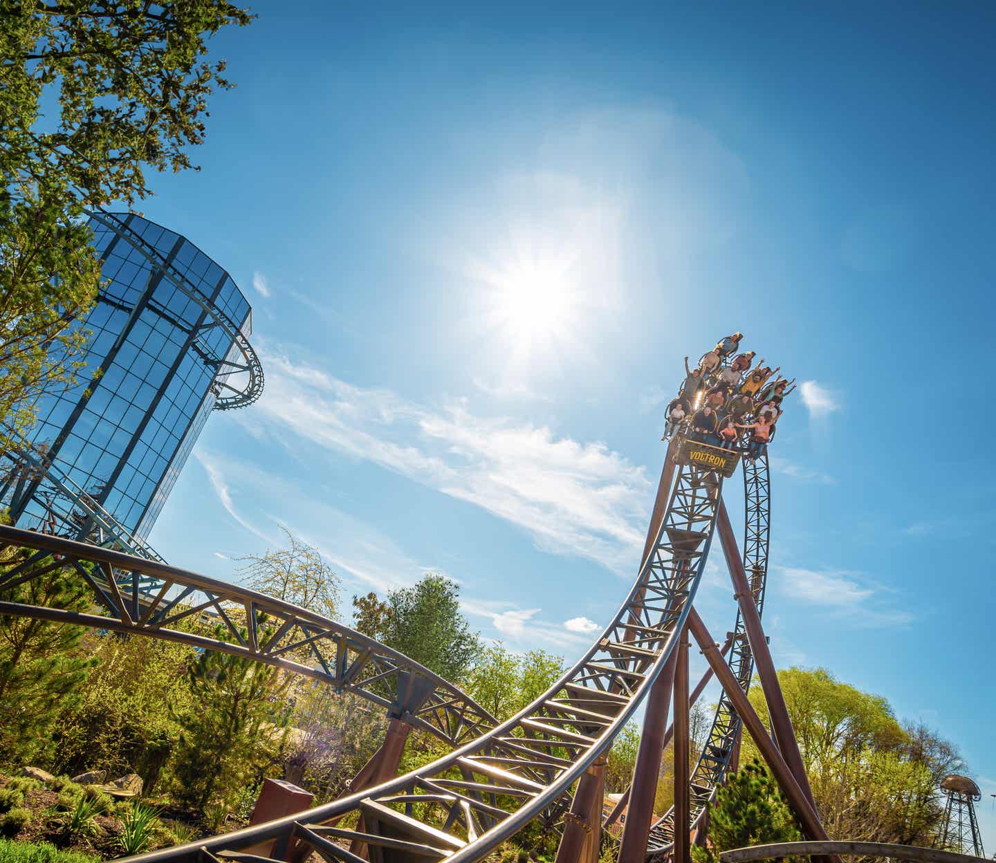 Blick auf eine Achterbahn die hoch vor einem sonnigen Himmel emporragt