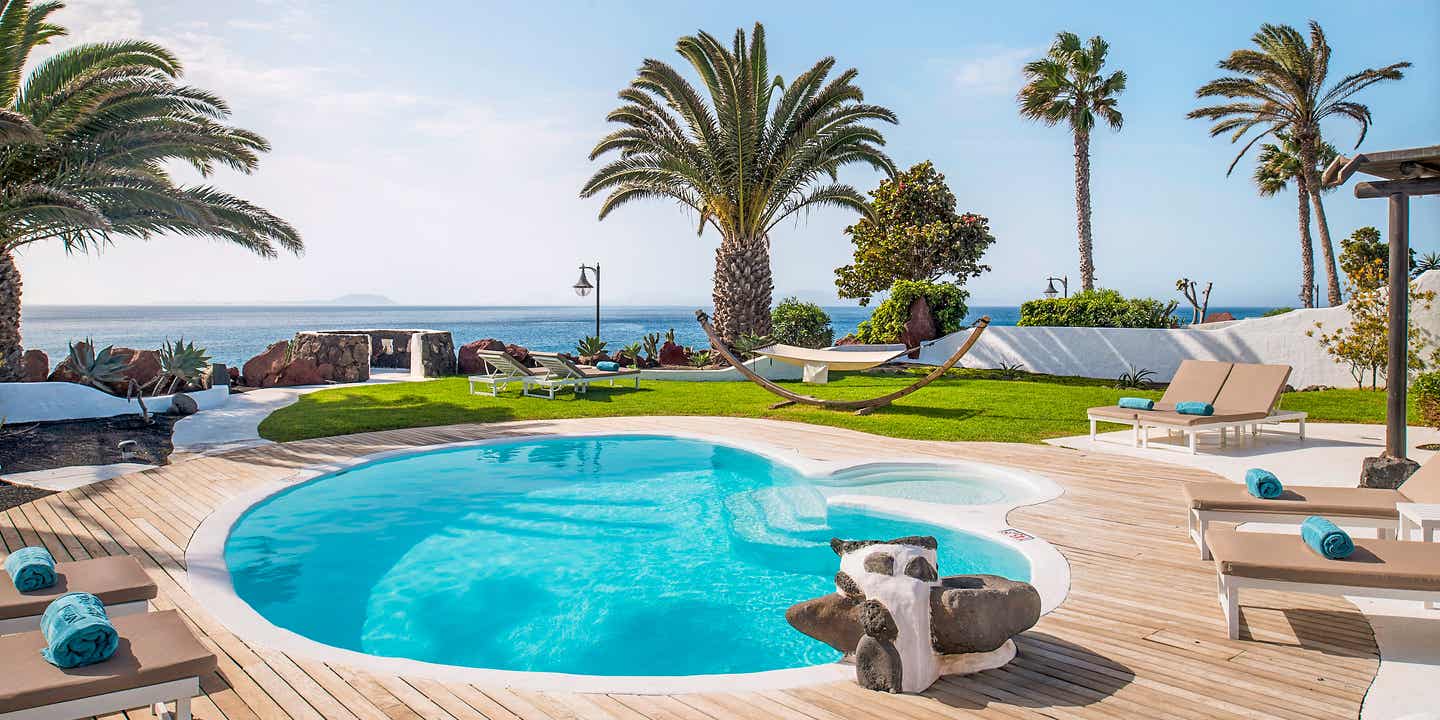 Blick auf den Pool und das Meer dahinter im Kamezi Boutique Villas auf Lanzarote
