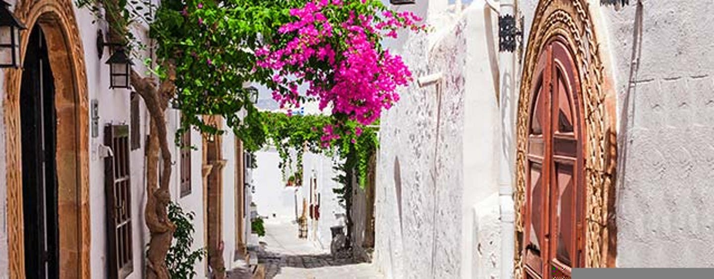 Rhodos Gasse mit weißen Häusern und Blumen