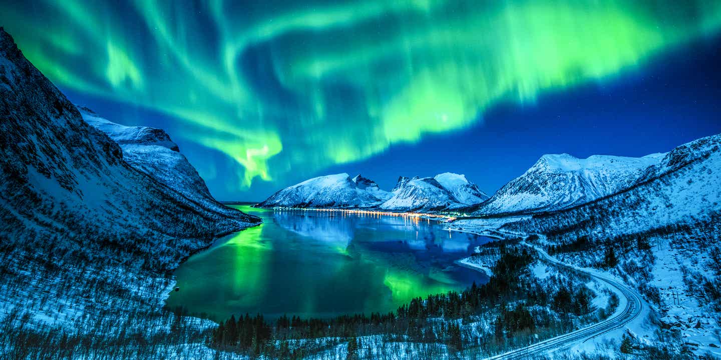 Polarlichter am Nachthimmel über einer Winterlandschaft in Nordnorwegen