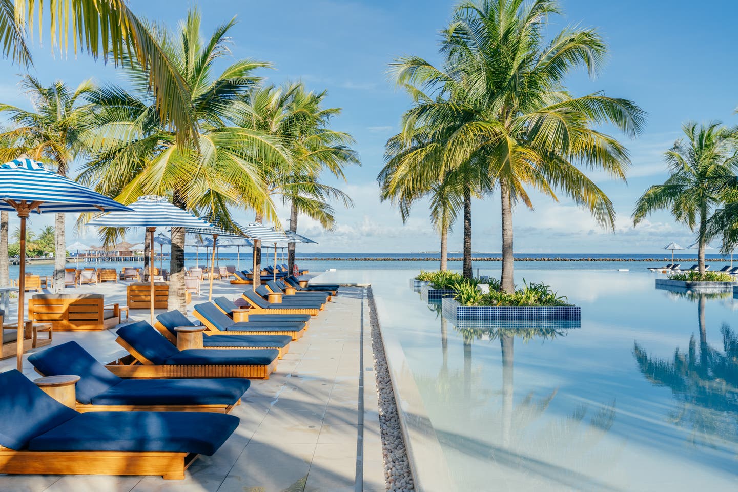 Sonnenliegen am Pool des Hotels direkt am Strand