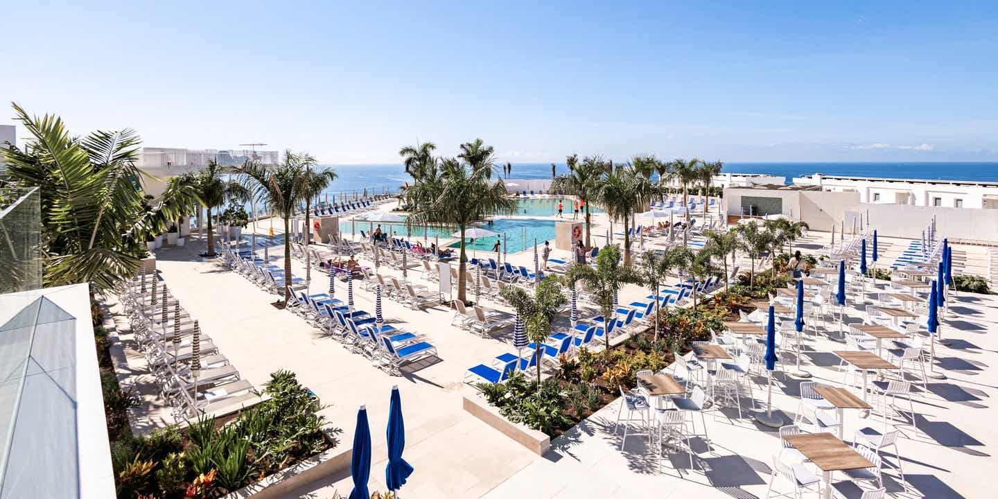Sonnenterrasse mit Pool und Liegen im Familienhotel Servatur Puerto Azul auf Gran Canaria mit Meerblick