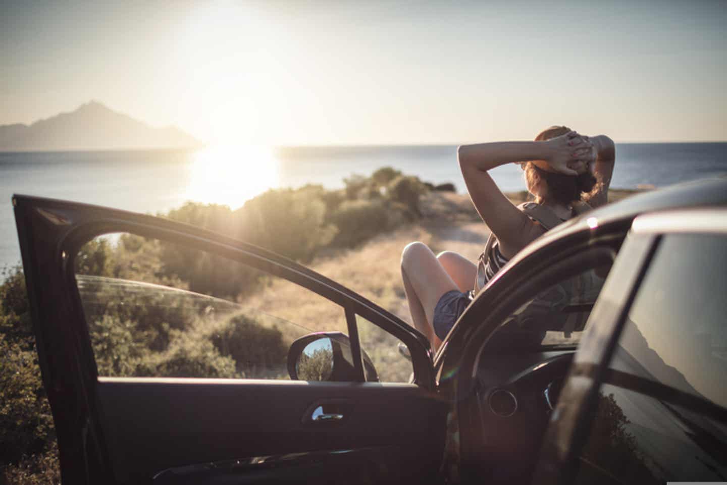 Hygienetipps für den Urlaub während Corona: Frau sitzt auf einem Auto