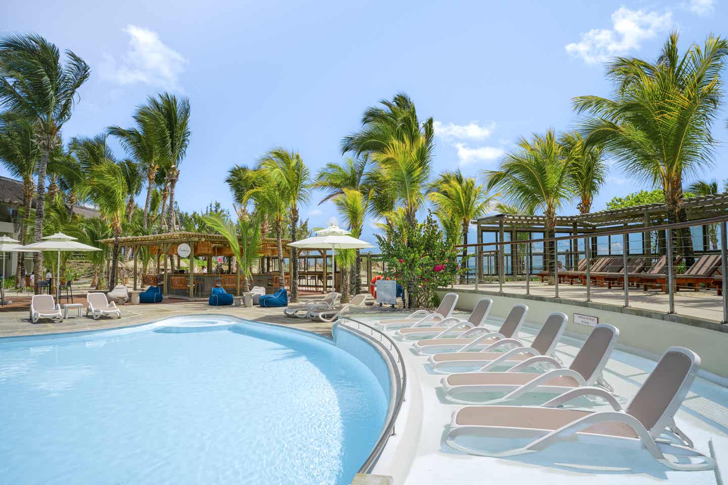 Pool mit Liegestühlen und Palmen