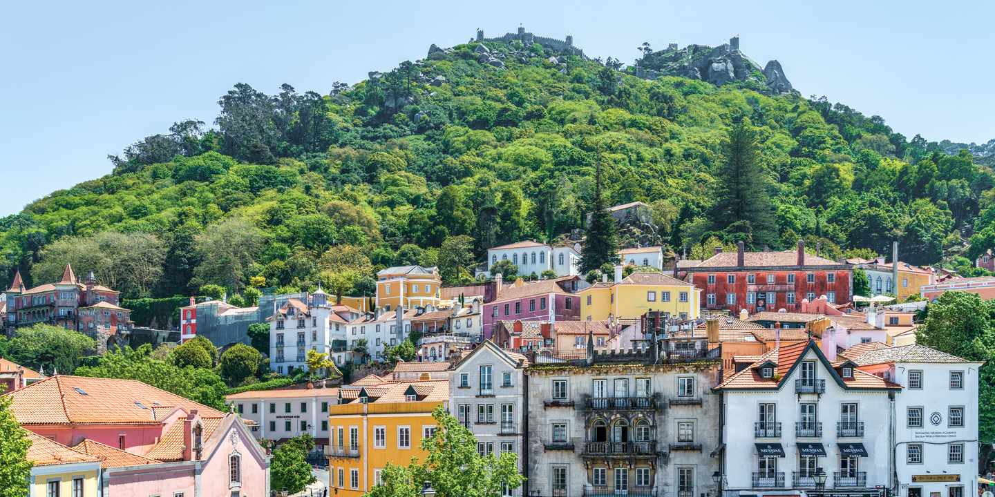 Blick auf Sintra mit bunten Häusern, Altstadt und bewaldeten Hügeln im Hintergrund