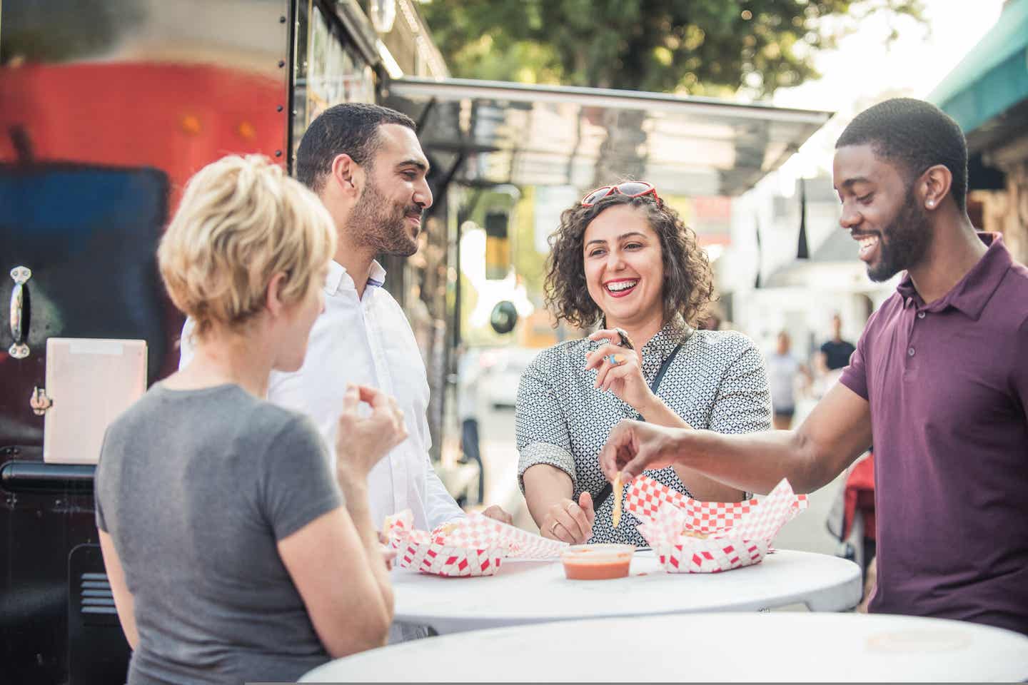 New York: Freunde stehen vor einem Food Truck und Essen