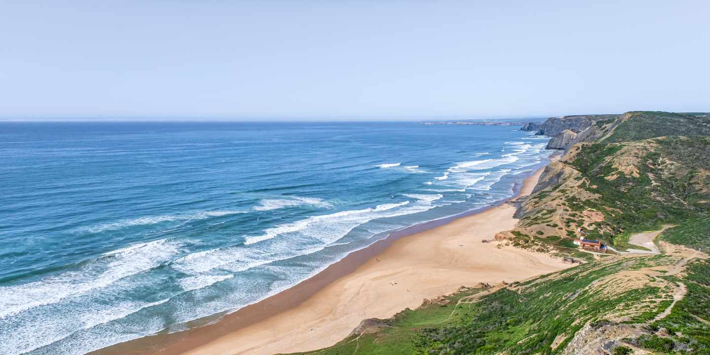 Praia da Cordoama an der Westalgarve mit breitem Naturstrand, Atlantikwellen und grünen Steilhängen