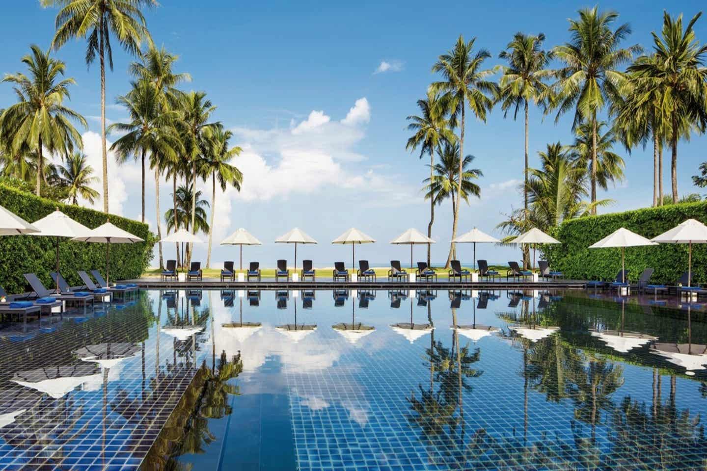 Pool, Liegen und Palmen im JW Marriott Khao Lak Resort & Spa