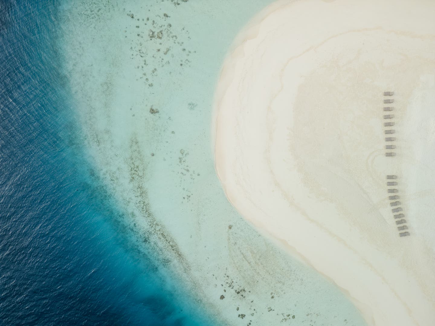 Topshot einer Drohne auf den weißen Hotelstrand und glasklares Meer