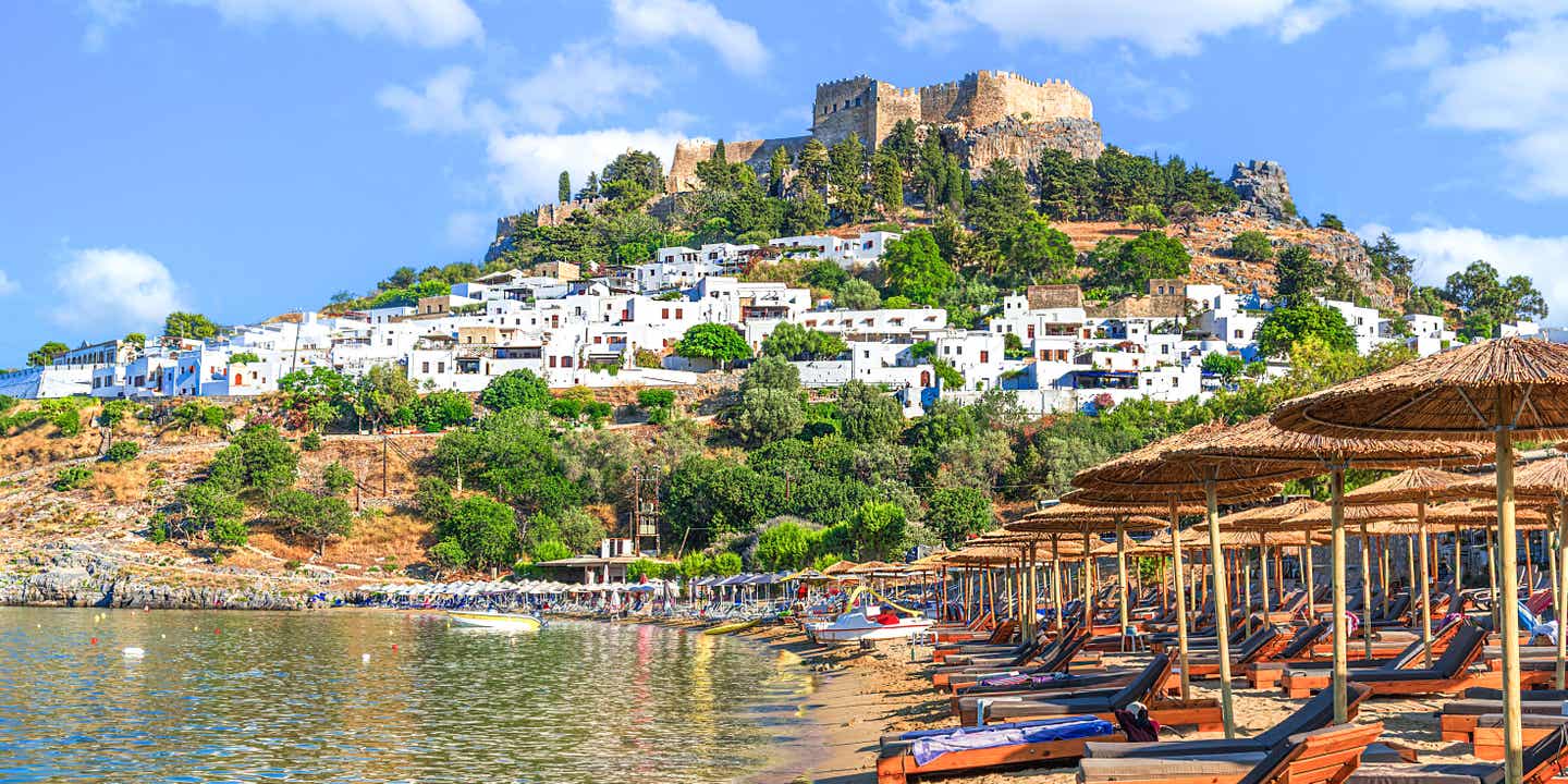 Blick auf den Strand von Lindos mit der Akropolis auf dem Berg dahinter