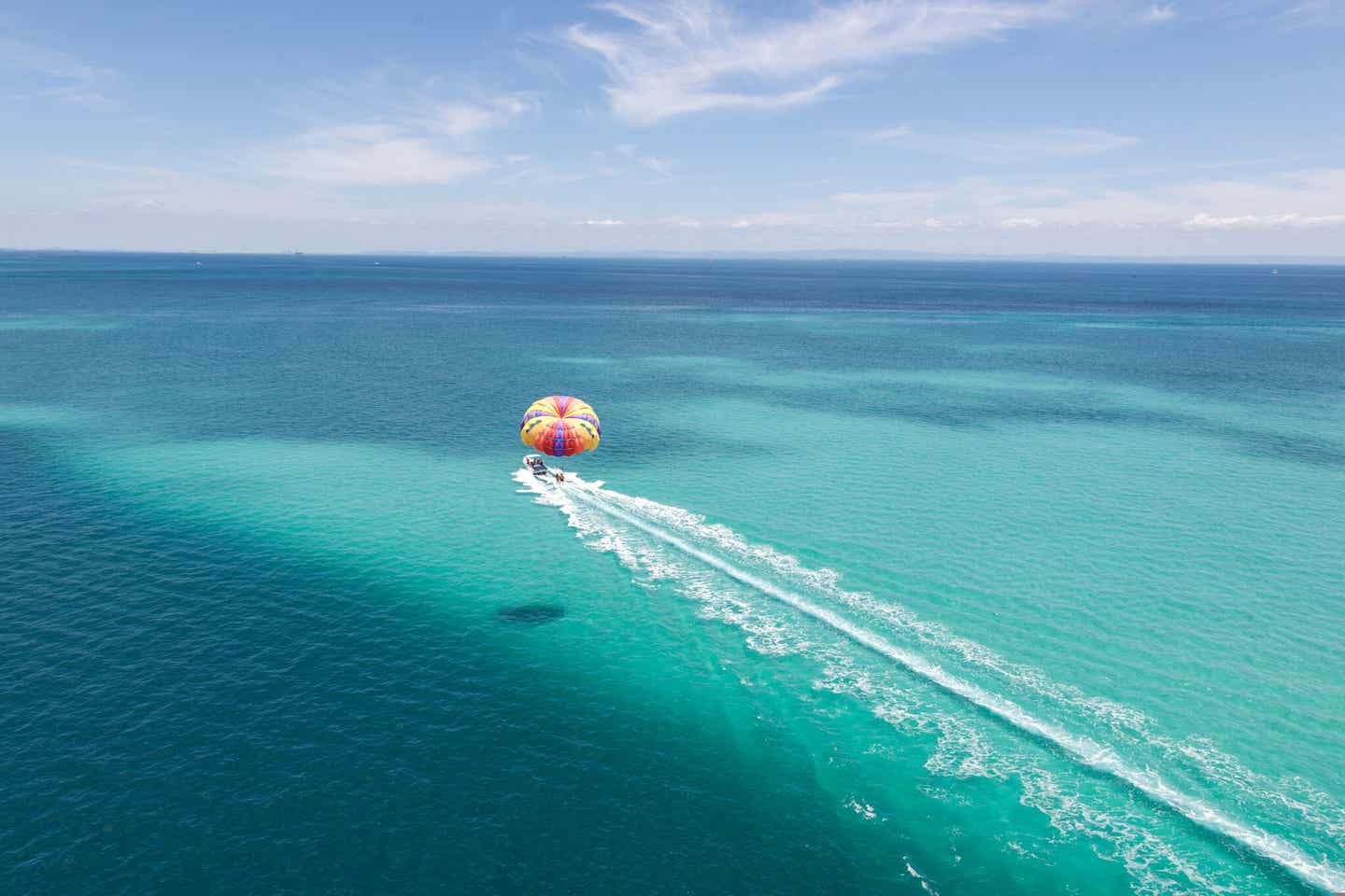 Parasailing über dem türkisblauem Meer bei Sonnenschein