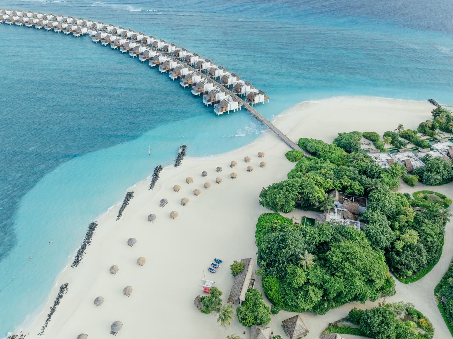 Drohnenaufnahme von Hotel, Strand und Wasservillen