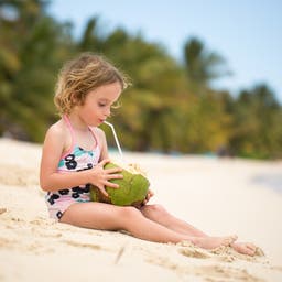 mauritius-kleines-maedchen-trinkt-am-strand-aus-einer-kokosnuss-g-1358019179.jpg