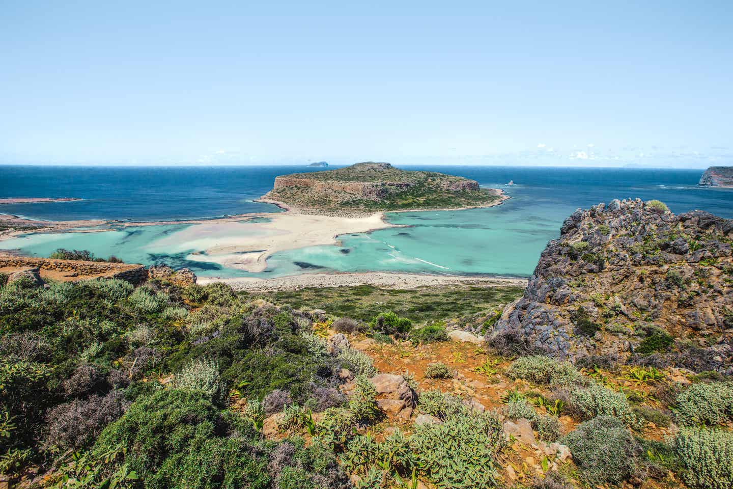 Blick auf Bucht von Balos auf Kreta von der Landseite aus; im Vordergrund die typische Inselvegetation, im Hintergrund die türkisfarbene Lagune