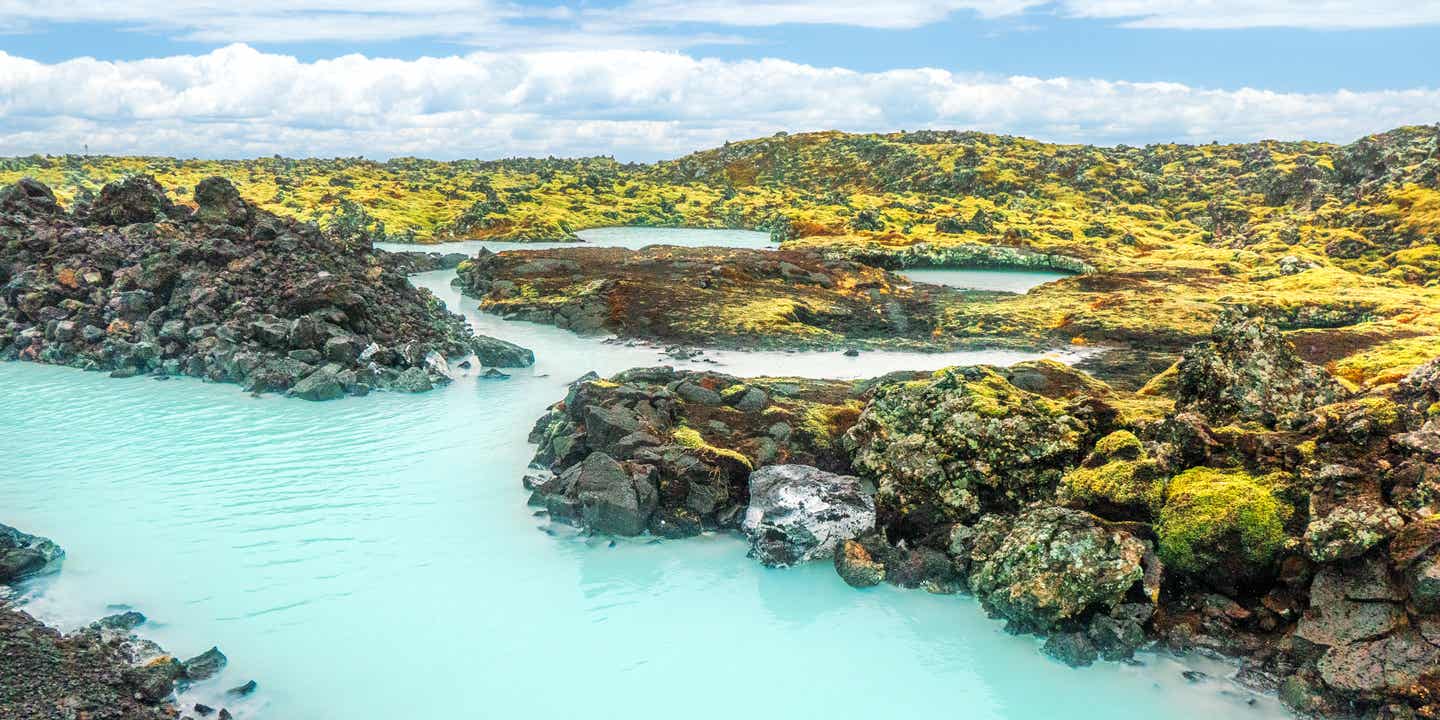 Türkisfarbenes Wasser in einer Lagune zwischen Felsen auf deiner Rundreise durch Island