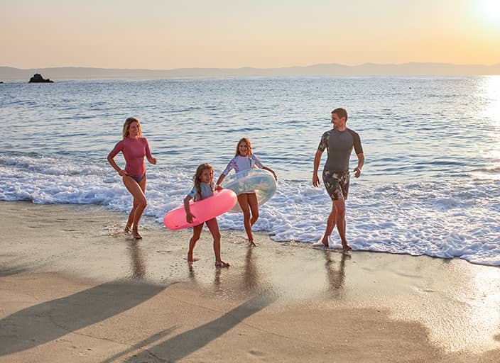 Familie rennt am Strand im Familienurlaub Familie rennt am Strand im Familienurlaub