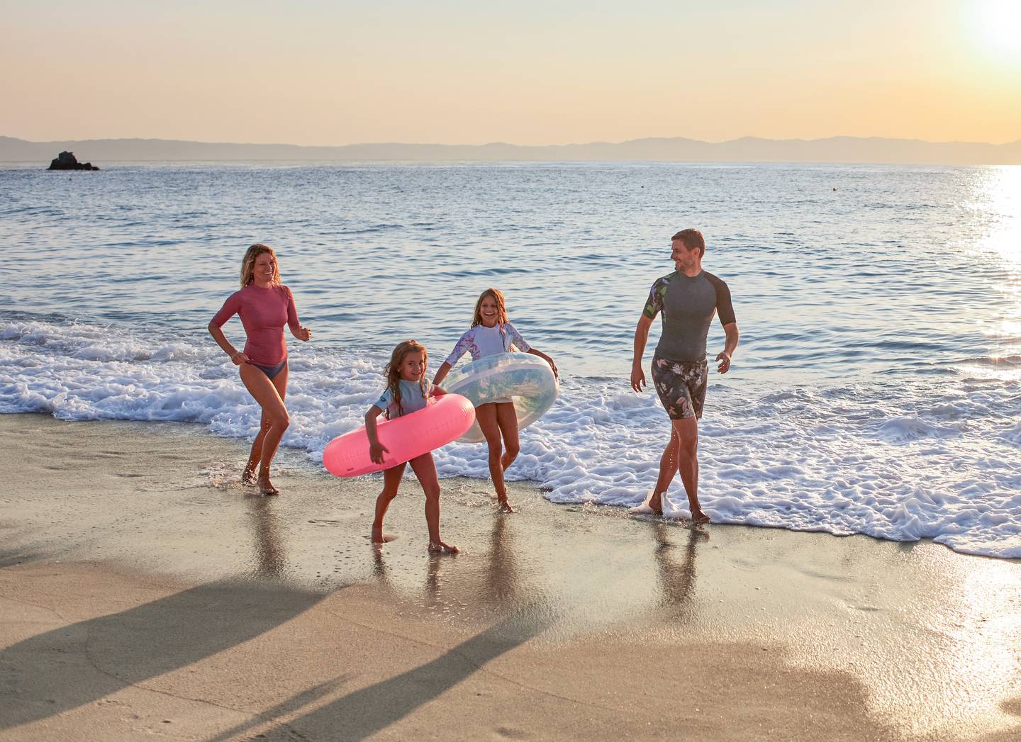Familie rennt am Strand im Familienurlaub Familie rennt am Strand im Familienurlaub