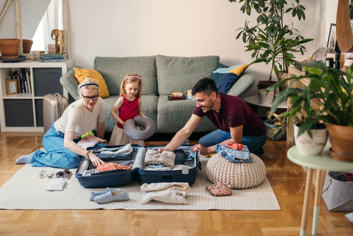 Urlaub mit Kindern: eine Familie packt zusammen den Reisekoffer