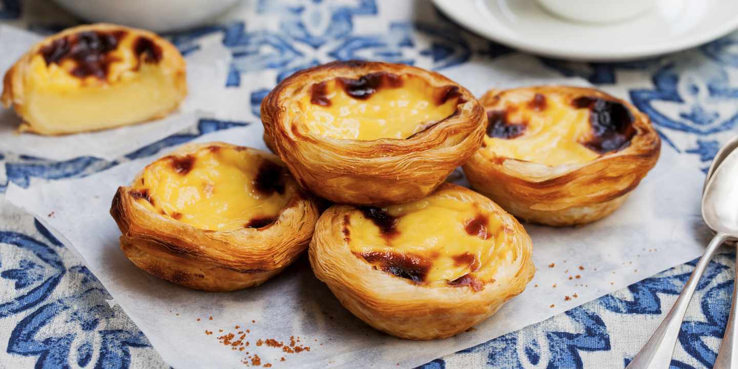 Frisch gebackene Pastéis de Nata mit goldbrauner Oberfläche in einer Bäckerei in Lissabon