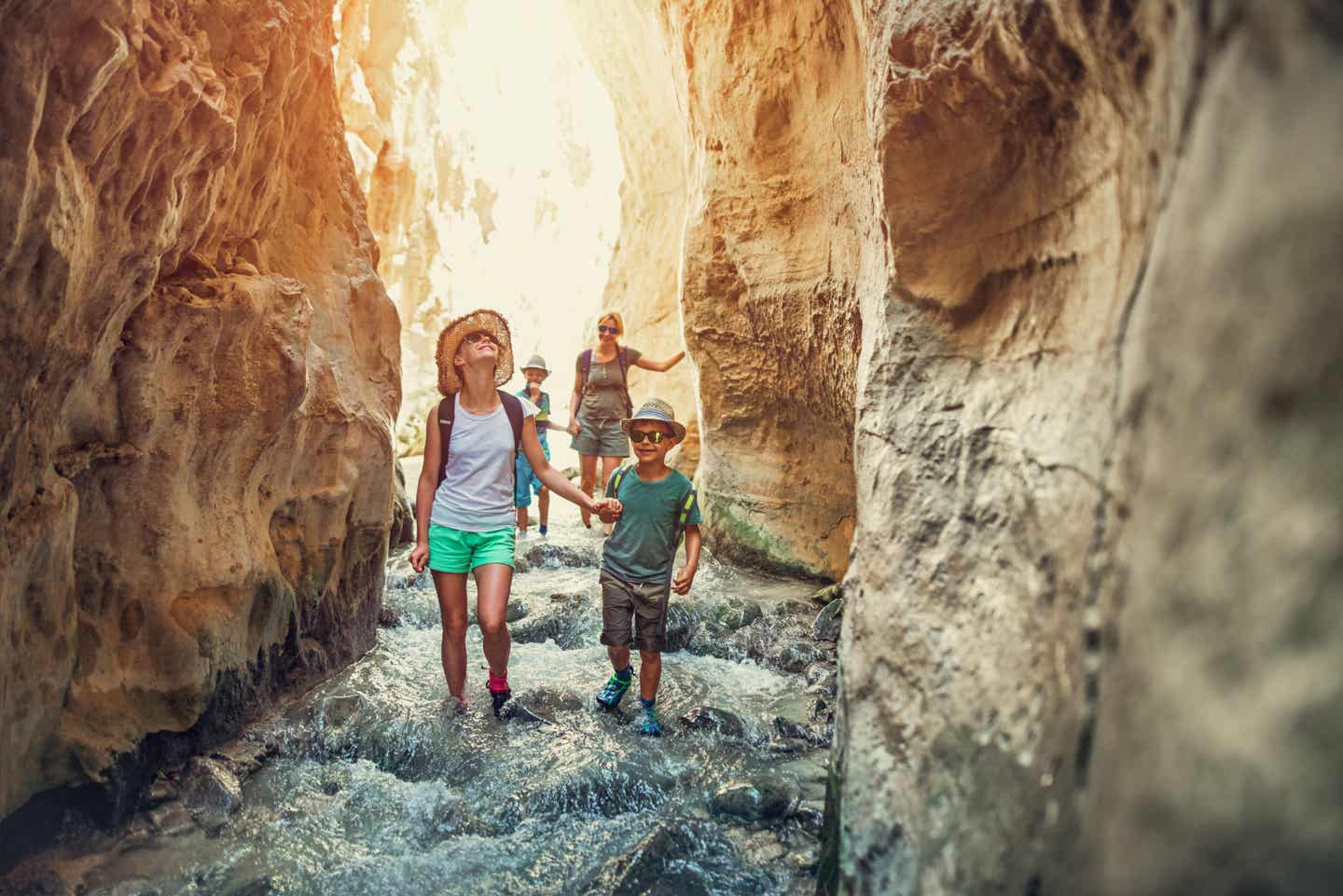 Familie wandert durch den Fluss im Canyon des Rio Chillar in Andalusien – kinderfreundliches Abenteuer mit Wasser und Felsen