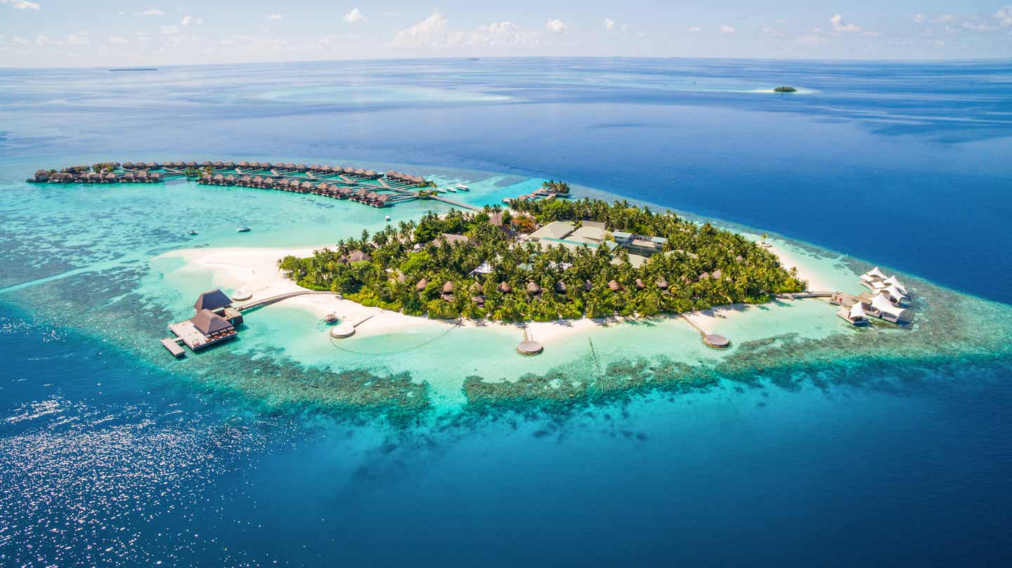 Malediven-Resort mit Overwater-Villen, Strand und Hausriff in türkisblauer Lagune