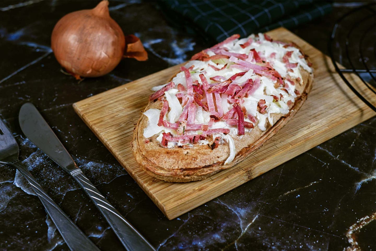 Brett mit einem Flammkuchen Elsässer Art