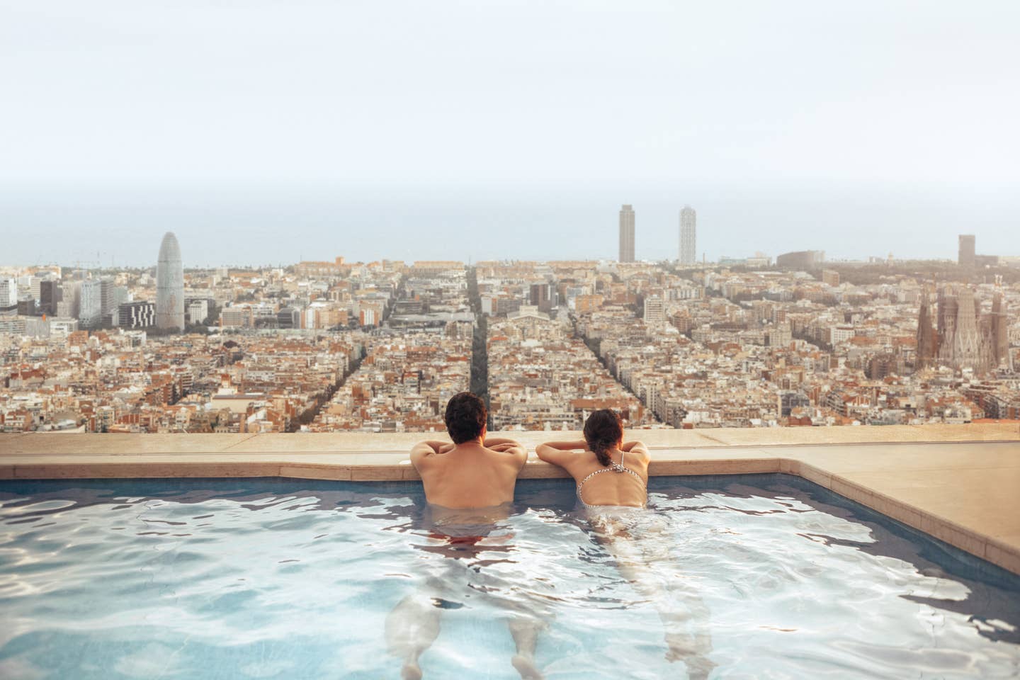 Last Minute Städtereise: Blick vom Pool auf einem Hoteldach auf Barcelonas Skyline