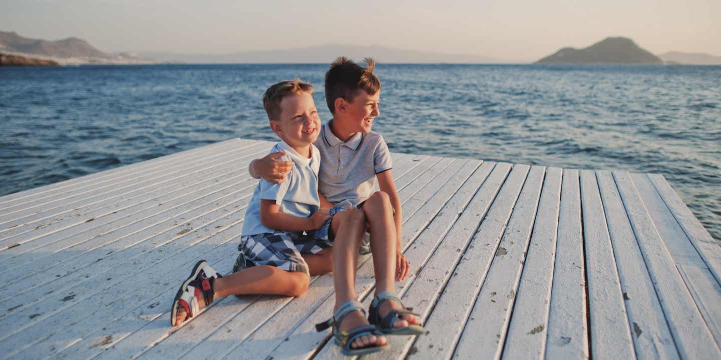 Familienurlaub in der Türkei: Zwei Jungs strahlen am Meer mit der Sonne um die Wette