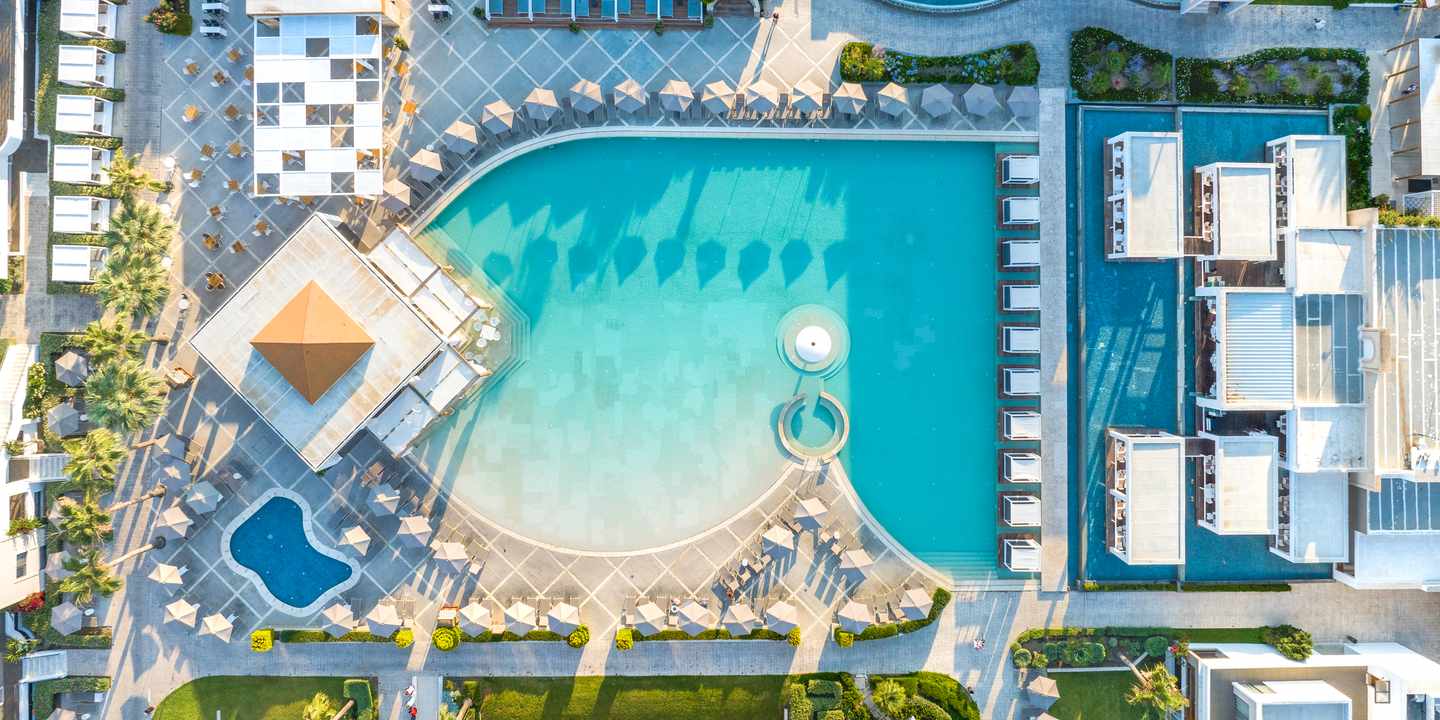 Poollandschaft im Sentido Pelagos Suites & Spa auf Kos aus der Vogelperspektive mit Hauptpool, Liegenbereichen und Hotelgebäuden