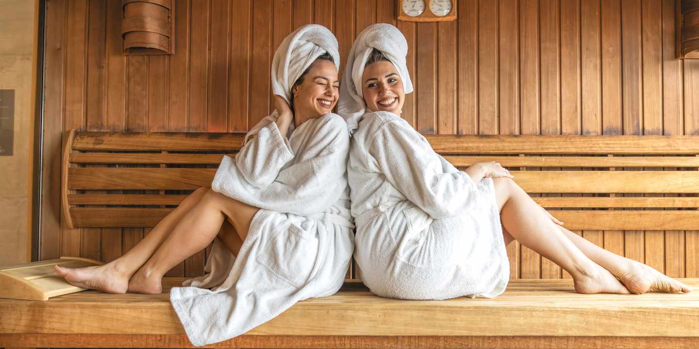 Zwei Freundinnen im Bademantel genießen gemeinsam einen Saunagang während eines Freundinnen Wellnesswochenendes