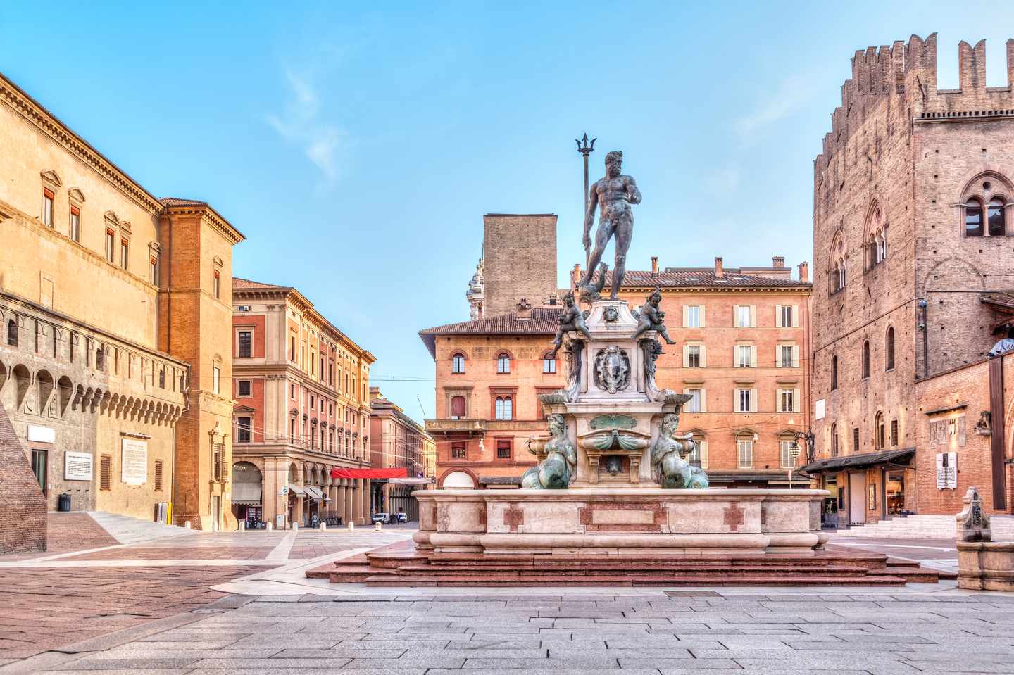 Neptunbrunnen auf der Piazza del Nettuno in Bologna vor historischen Palazzi bei blauem Himmel