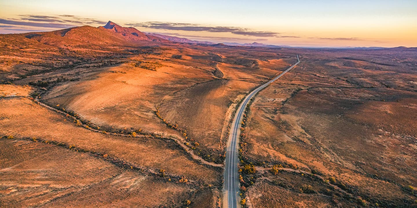 Schönster Roadtrip: Luftaufnahme des Outback Highway bei Sonnenuntergang in den Flinders Ranges in Südaustralien