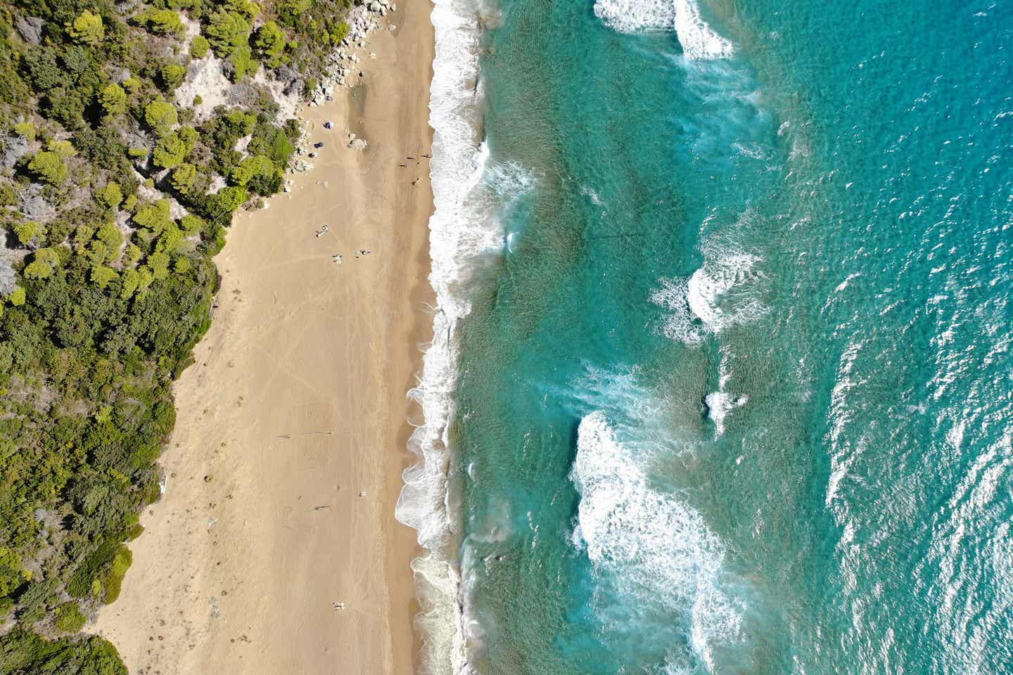 Der Strand Glyfada Beach auf Korfu mit Bäumen Sand und Meer