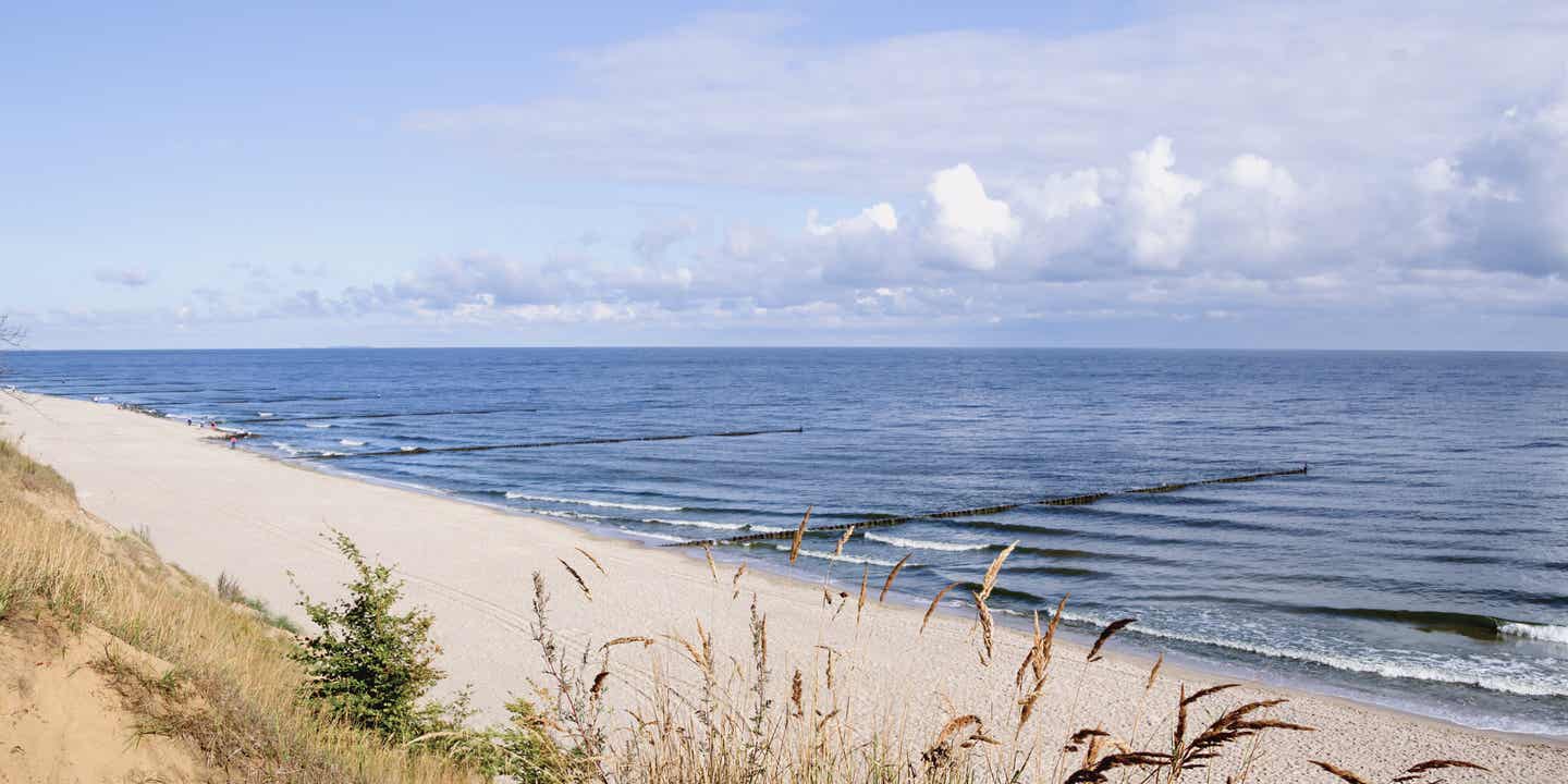 Familienurlaub Deutschland: Aufnahme eines leeren Strandes an der Ostsee im Morgenlicht