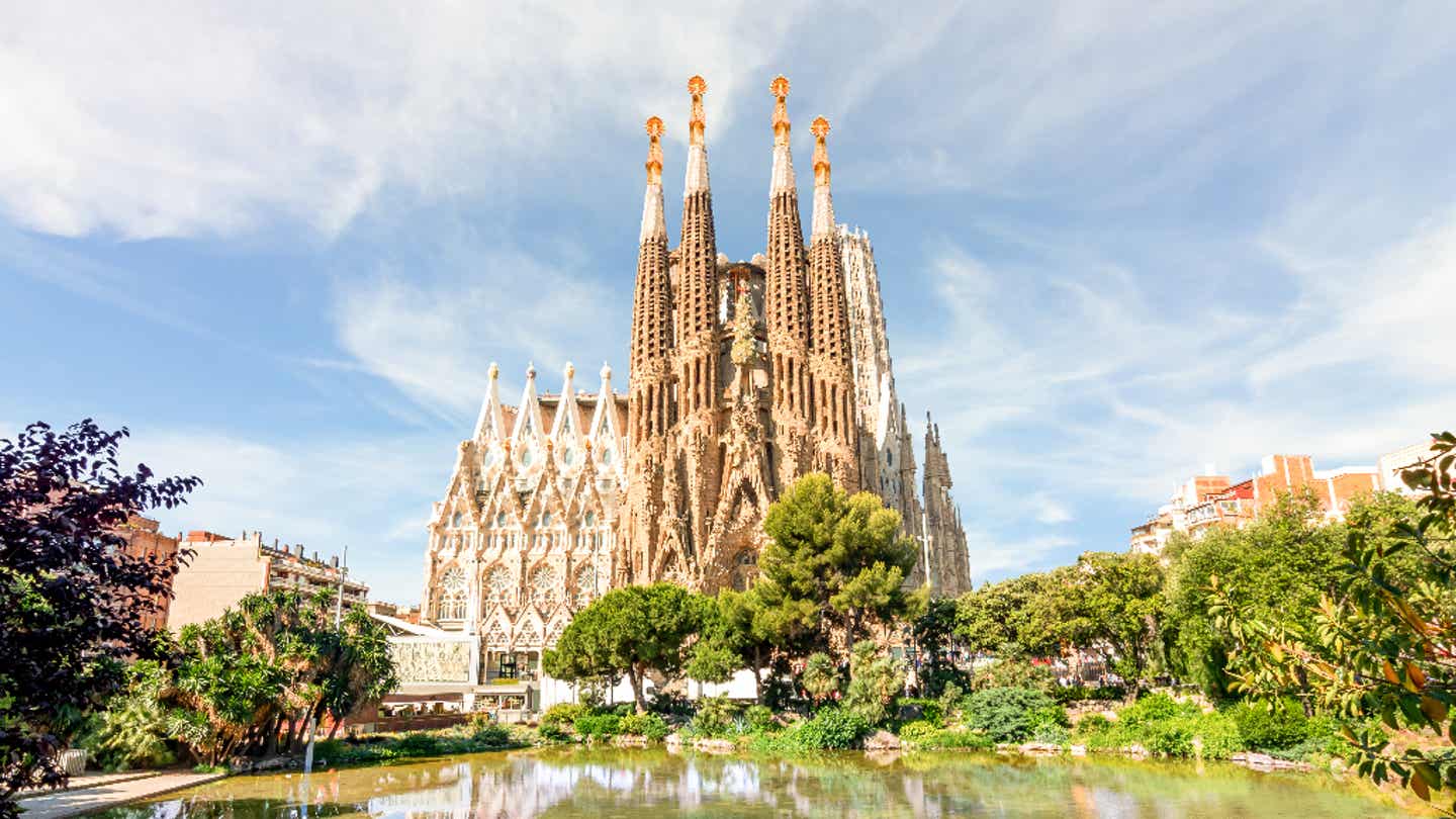Sagrada Família im Frühling mit Bäumen und Spiegelung im Wasser – Gaudís Meisterwerk in Barcelona