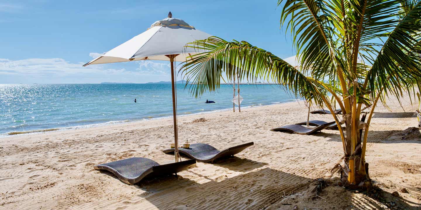 Zwei elegante Liegen unter einem weißen Sonnenscam am gepflegten Ban Amphur Beach