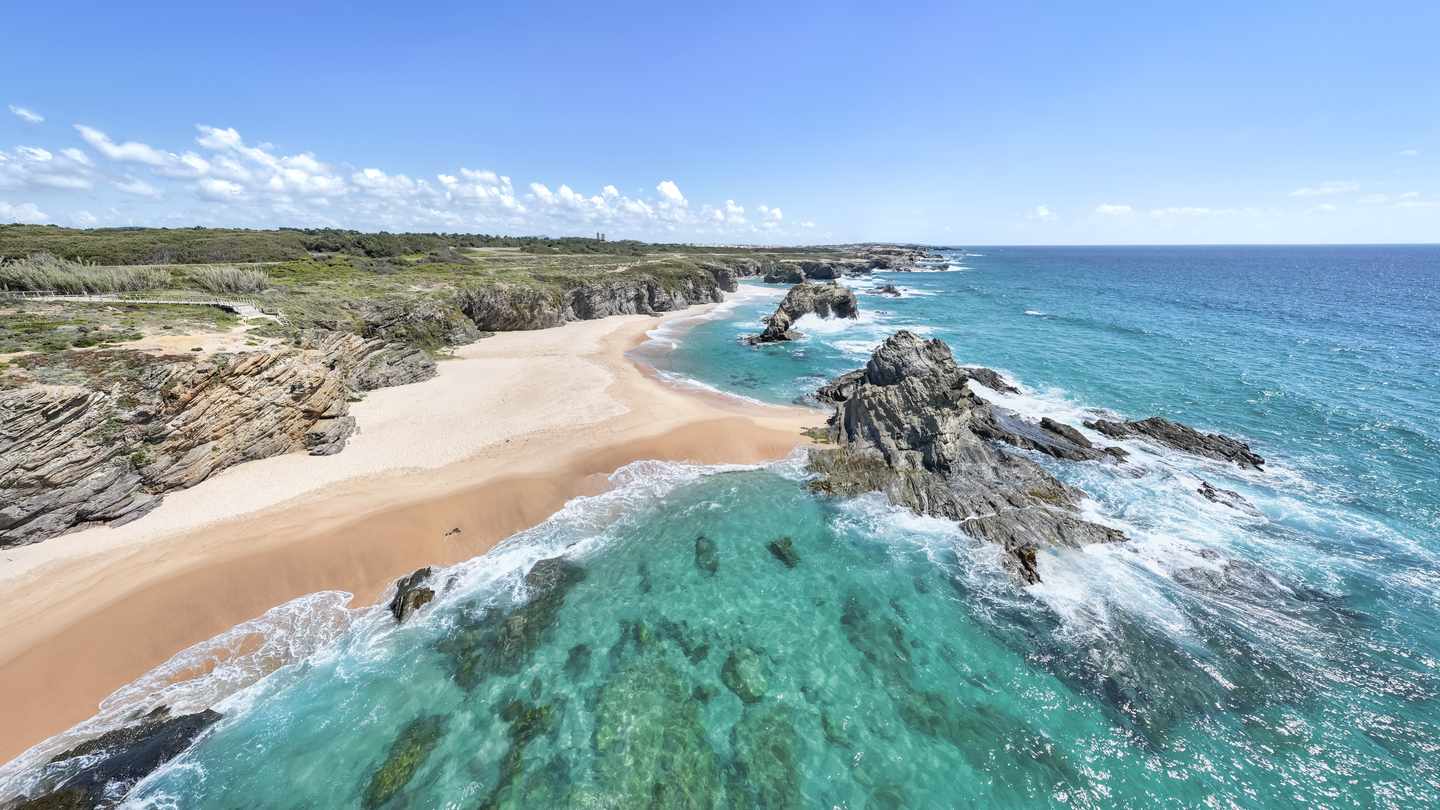 Küstenlandschaft bei Sines im Alentejo mit hellem Sandstrand, Felsen und türkisfarbenem Atlantik