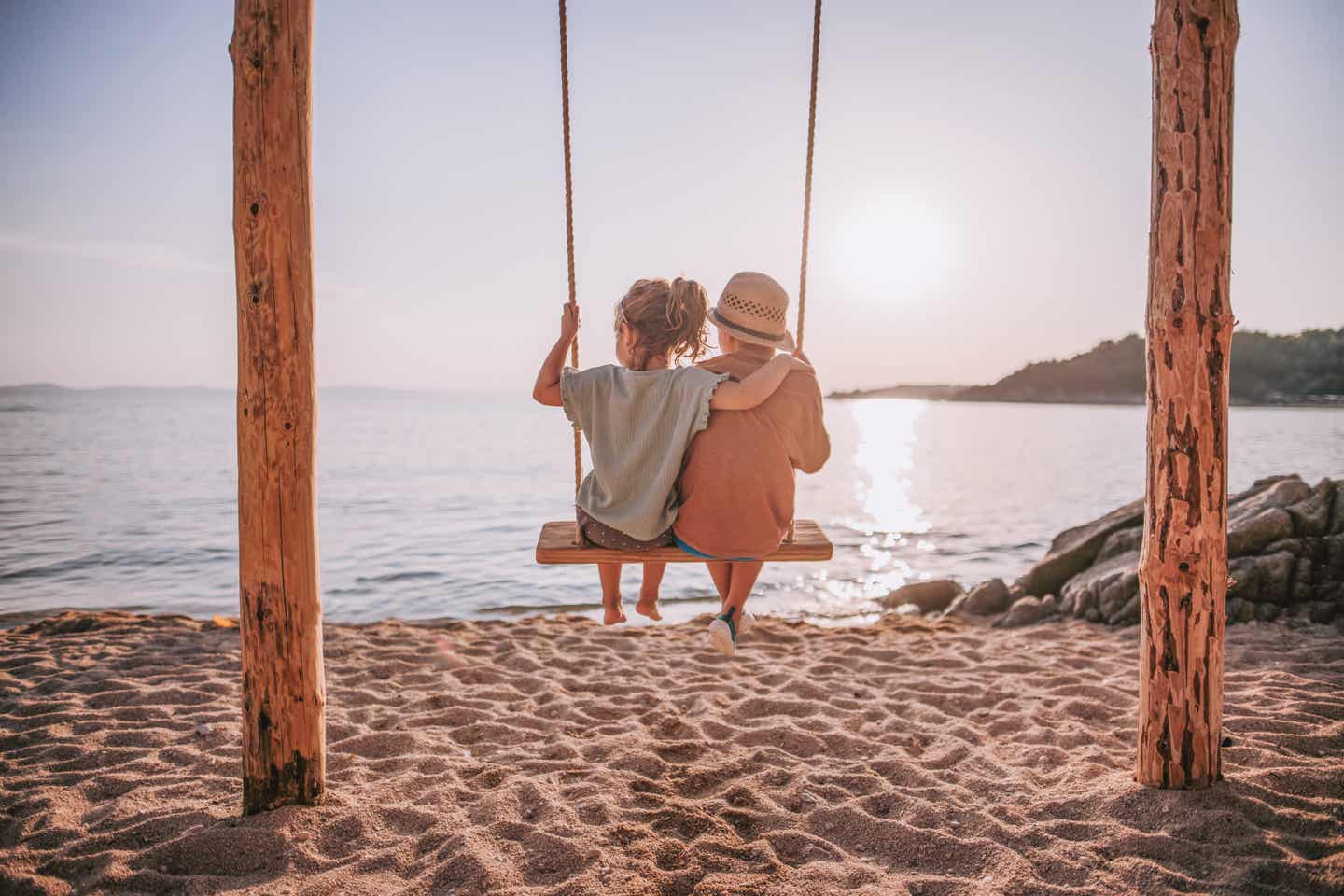 Kinder auf einer Schaukel am Strand