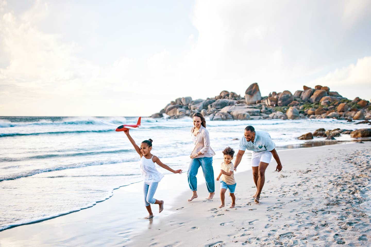 Junge Familie spielt zusammen am Strand