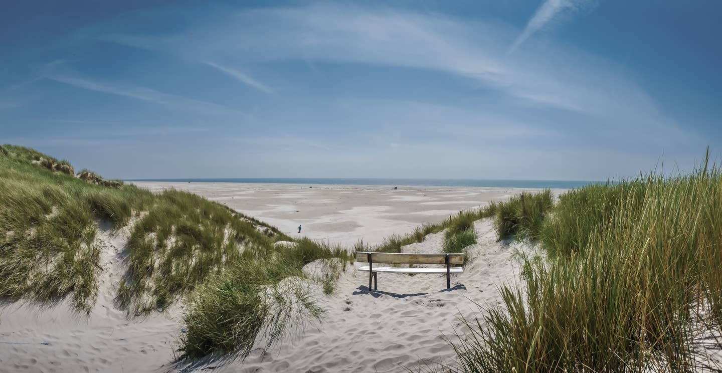 Schleswig Holstein Urlaub mit DERTOUR. Dünenlandschaft an der Nordsee mit dem Meer im Hintergrund