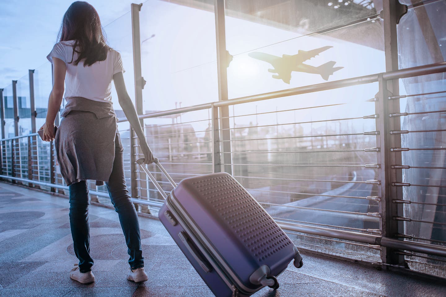 Frau mit Koffer am Flughafen