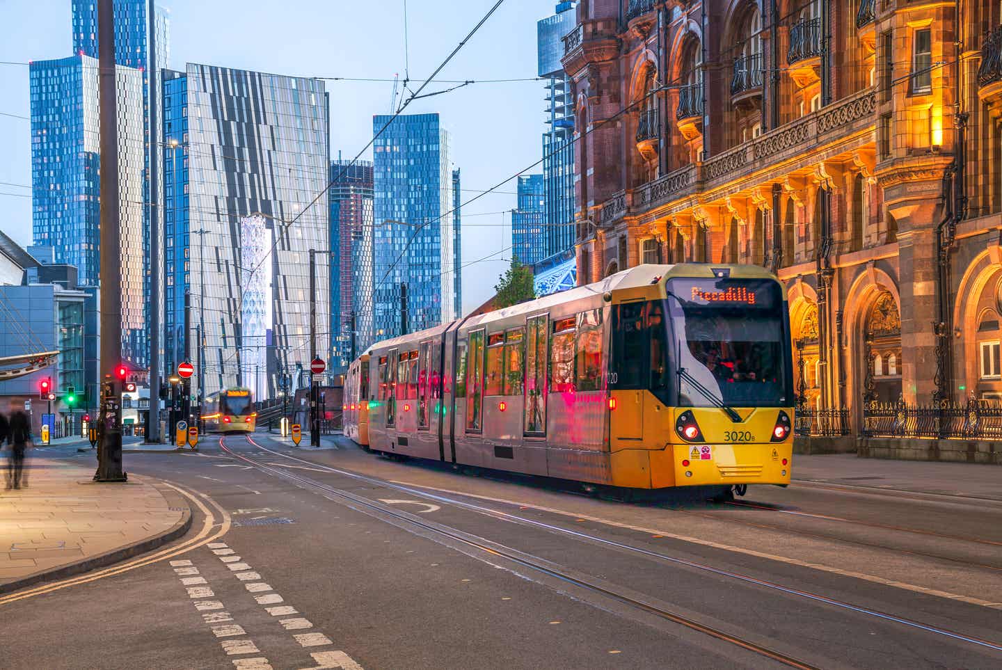 Altstadthäuser treffen auf Skyscraper in Manchester Straßenbahn fährt zwischen Altstadthäusern mit Hochhäusern im Hintergrund