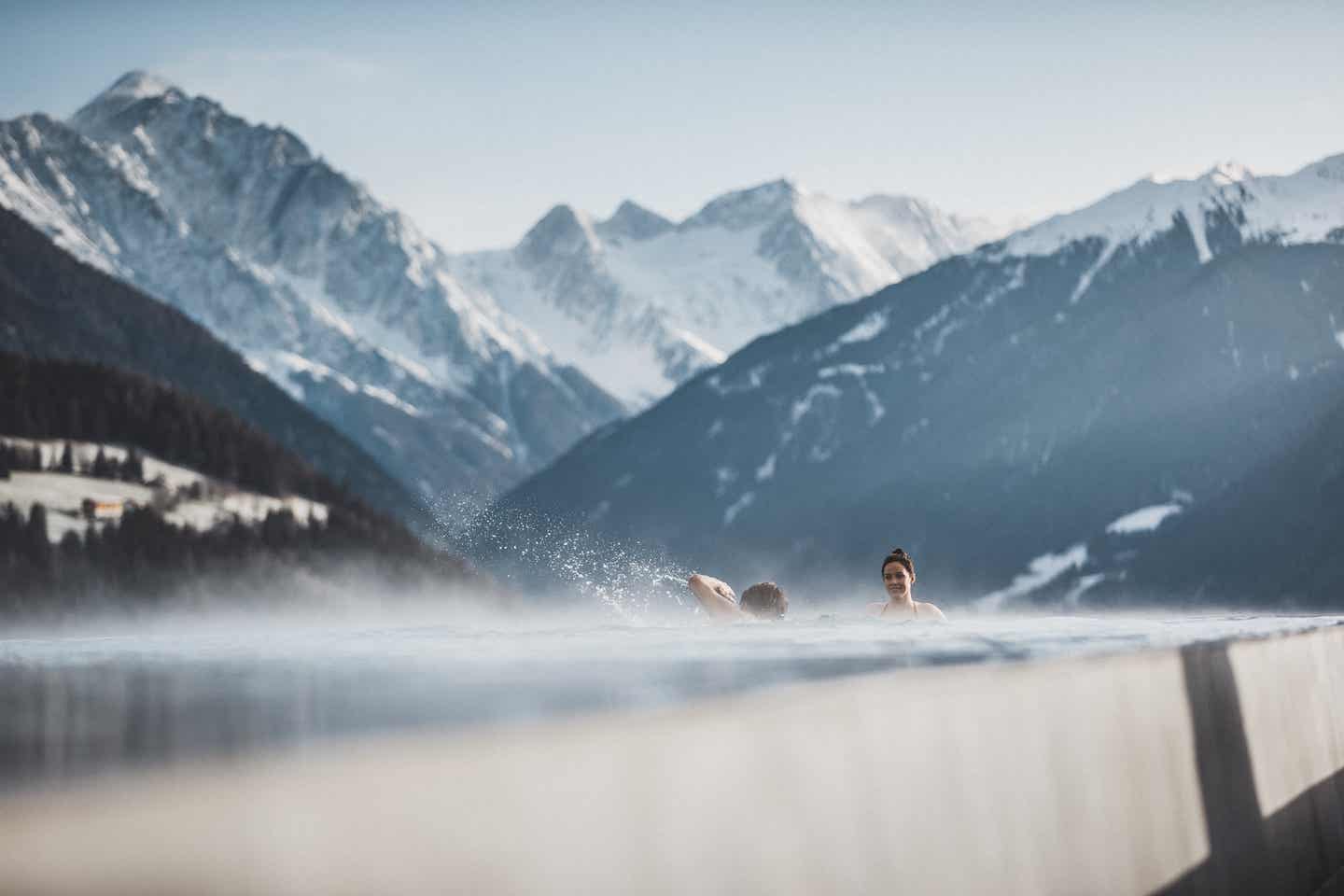 Paar im Pool: Tiroler Hotels mit Pool zwischen den Bergen