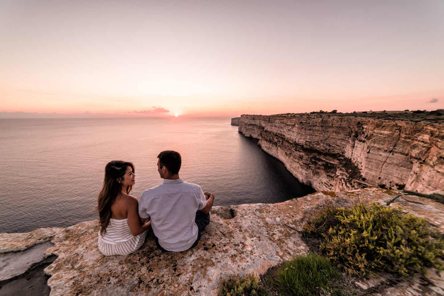 Malta Urlaub mit DERTOUR. Paar genießt den Sonnenuntergang auf den Ta-Cenc-Klippen bei Gozo auf Malta