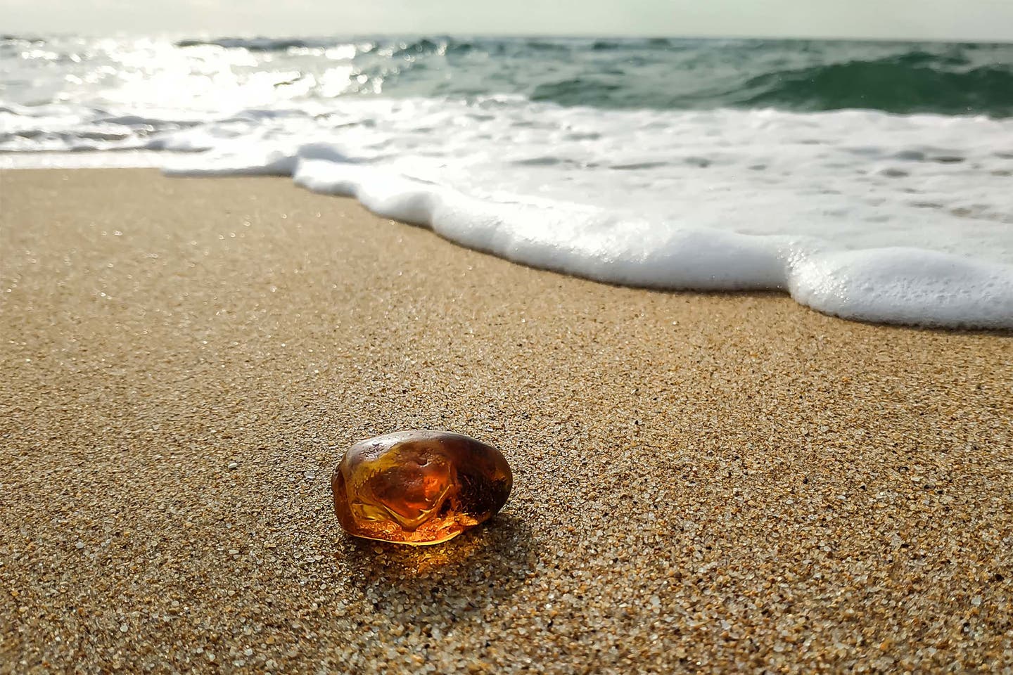 Deutschland Ostsee - orangener Stein am Strand