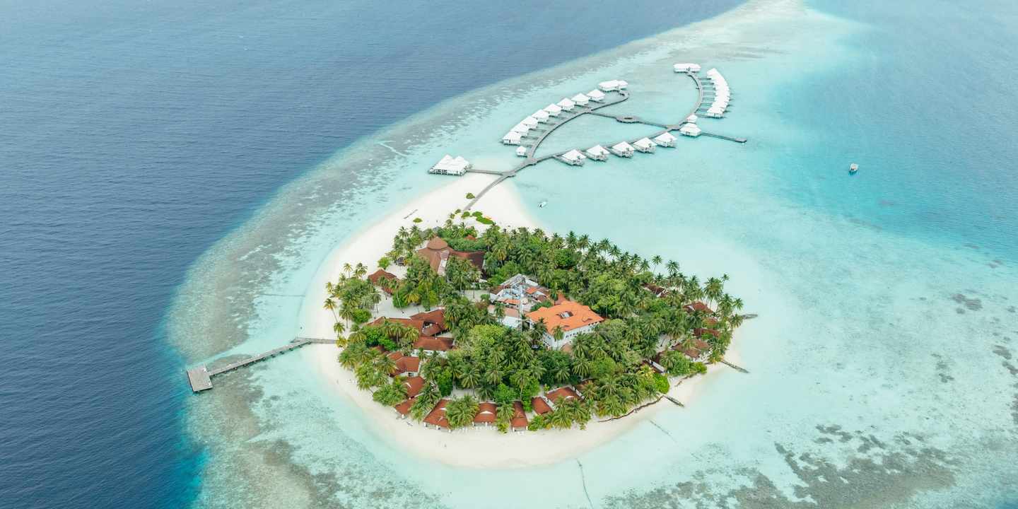 Blick auf die fast kreisrunde Malediven-Insel, auf der das ananea Diamonds Athuruga Resort liegt