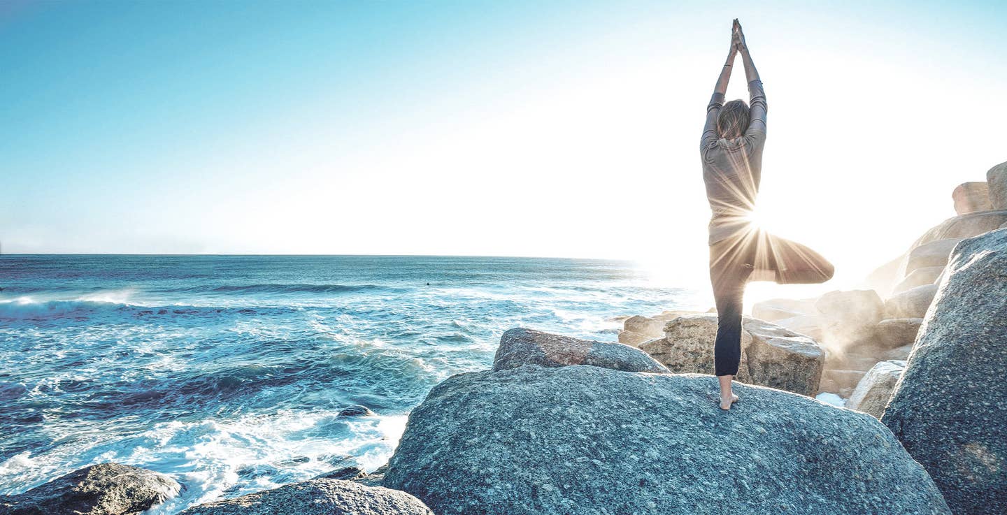 Person macht Yoga am Strand