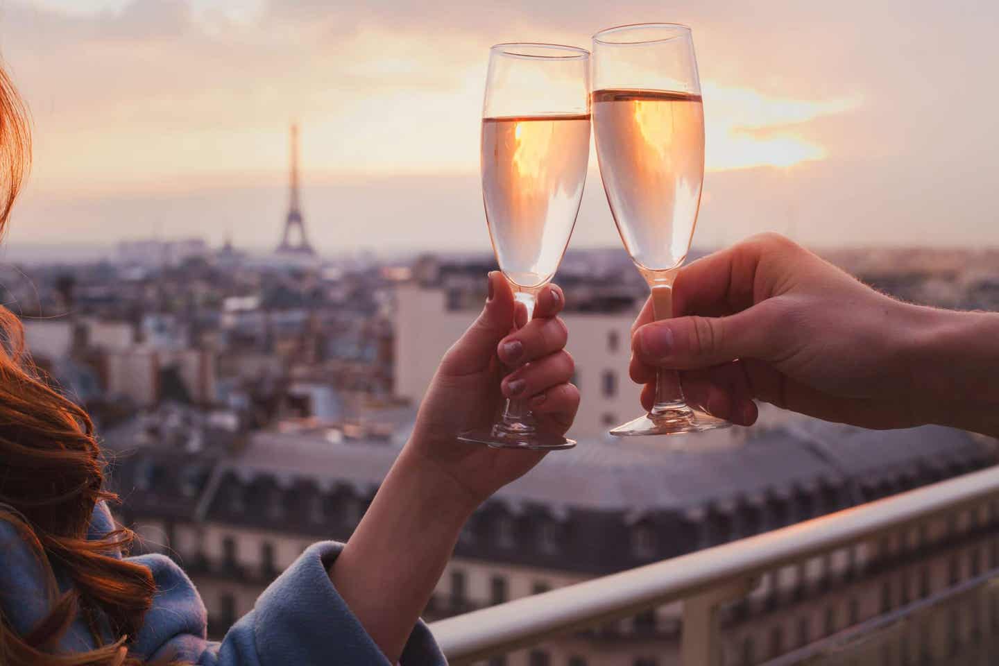 Paar stößt mit Champagner und mit Blick auf den Eiffelturm an