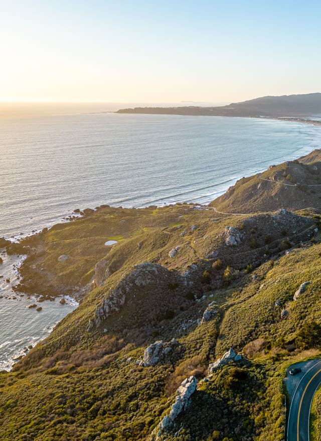 Rundreisen Rundreisen: eine kurvige Straße schlängelt sich durch eine grüne Küstenlandschaft in Kalifornien