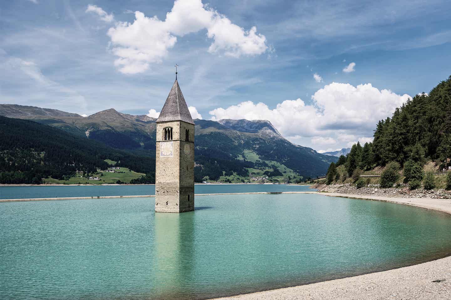 Der Kirchturm von Altgraun im Bergsee der Tiroler Alpen